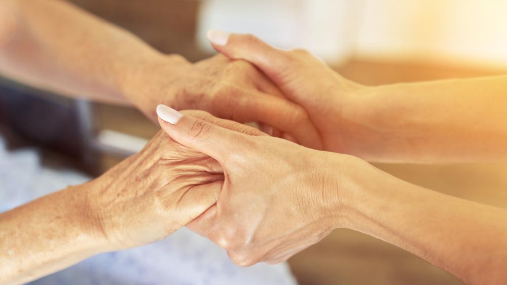 Personne agée tendant les mains